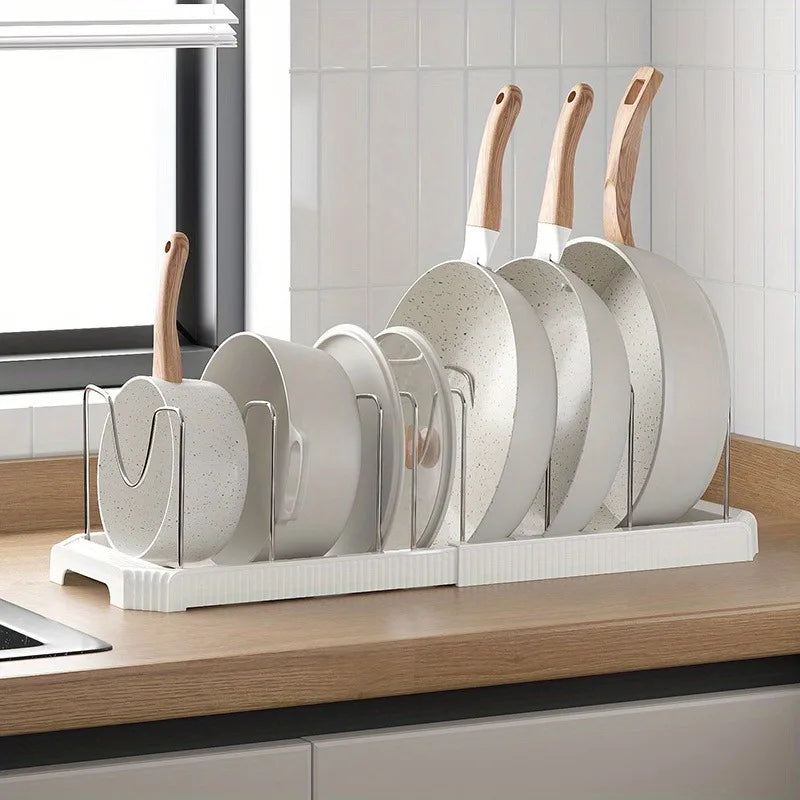 A silver organizer rack holds several round pots and pans with wooden handles.