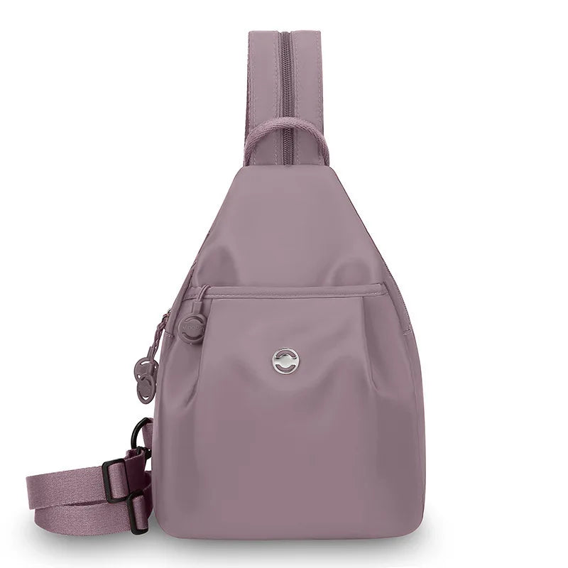 A light purple women's mini backpack with a strap and a flap closure.