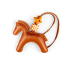 A small brown leather pony charm with a gold-colored tag and leather strap.
