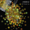 A pile of shiny holographic star sequins in various colors scattered on a black background.