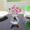 Crystal rose sculpture with a bouquet of pink and purple reflective flowers displayed on a glass base