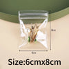 Clear self-sealing jewelry storage bag containing gold-toned earrings and other small jewelry items