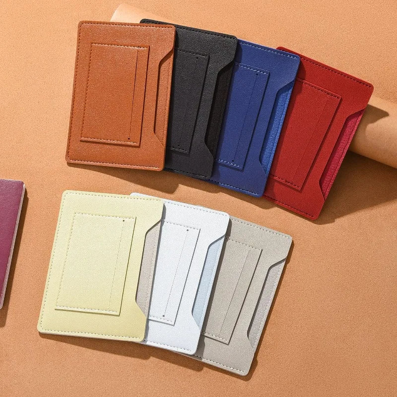 A set of five ultra-thin passport holders in various shades of brown, blue, and red are displayed on a tan surface.