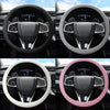 Four views of a steering wheel covered in soft silicone material in black, white, and pink colors.