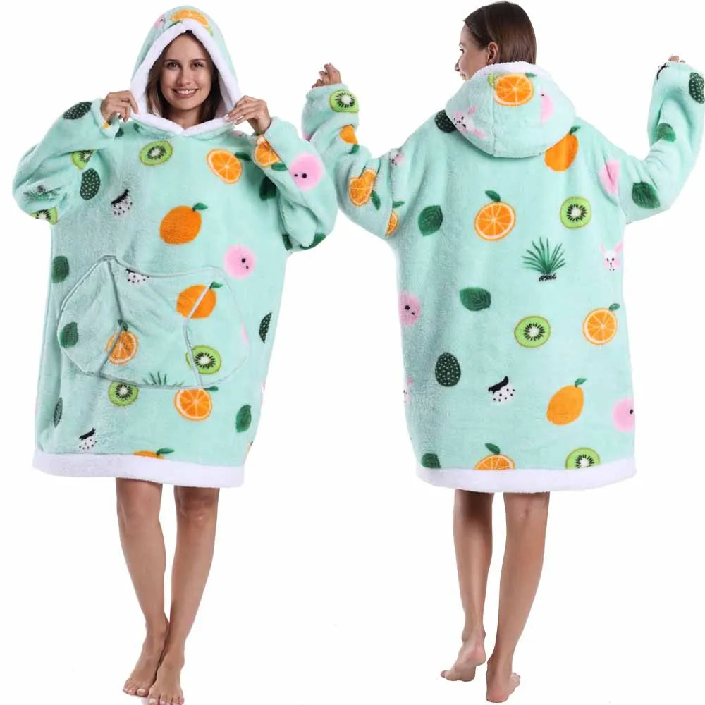 Eine Frau modelliert einen großzügigen, mintgrünen Patchwork-Fleece-Hoodie mit Stickereien aus Früchten und Blättern.
