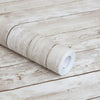A roll of retro wood grain self-adhesive wallpaper lying on a light wooden surface.