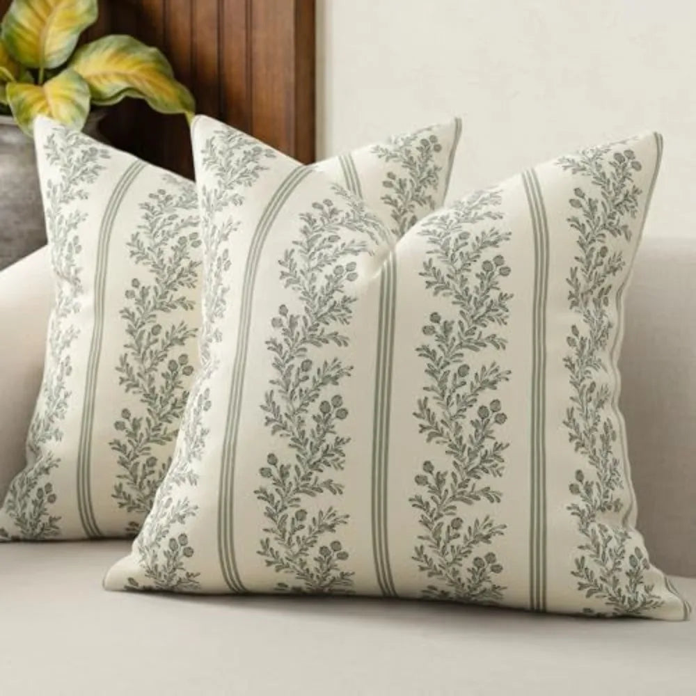 A close-up of a vintage striped floral throw pillow cover with sage green and cream tones.