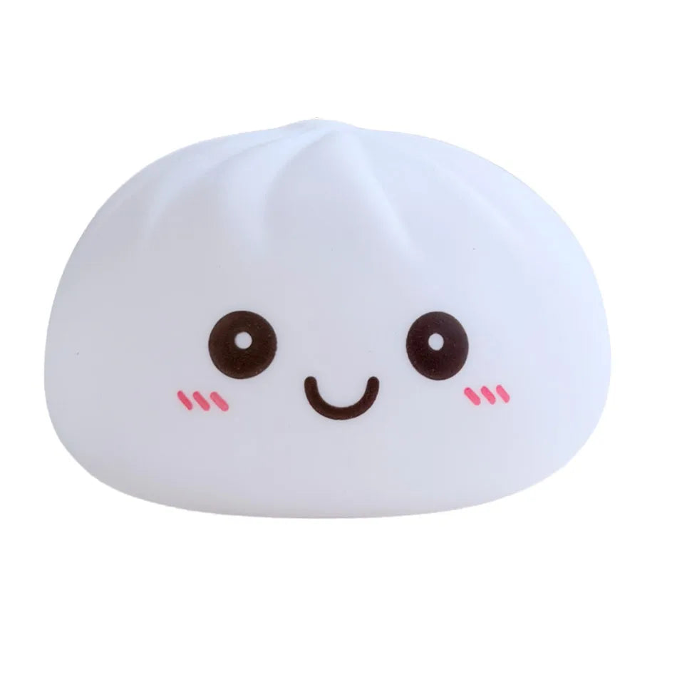 Juguete suave redondo blanco con forma de dumpling sonriente y rasgos faciales simples.