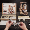 A wooden space shuttle model kit is being held by hands, displayed alongside a fully assembled model and parts.