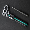 A silver key fob with a protective black TPU cover and a metal tool attached, resting on a dark surface.
