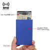 A blue slim metal RFID blocking card holder is shown with a card inserted and an out card visible.
