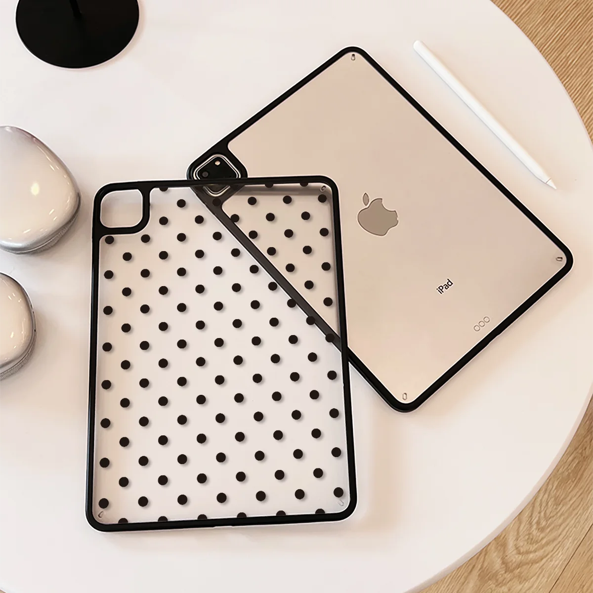 A light-colored iPad is shown alongside its black polka dot protective case on a white surface.