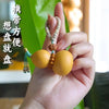A hand holds a set of handcrafted ceramic gourds used for wine, featuring a net bag and decorative string.