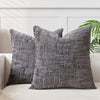 A dark gray handwoven chenille texture cushion cover resting on a light-colored sofa.