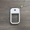 White silicone protective case for a hand sanitizer spray attached to a gold-colored keyring