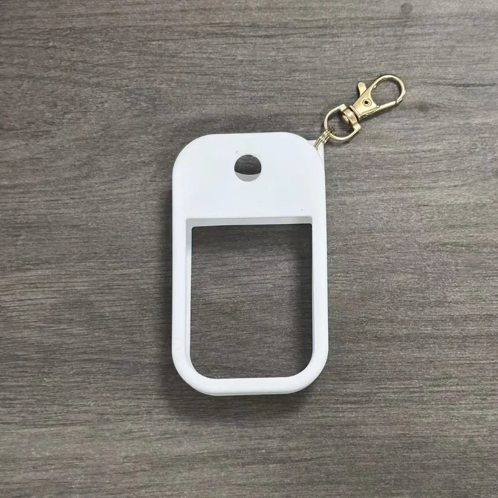 White silicone protective case for a hand sanitizer spray attached to a gold-colored keyring