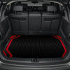Interior view of a car trunk with black leather seats and a black and red textured floor mat.