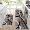 A gray and white geometric non-slip rug with black curved lines placed on a light wood floor.