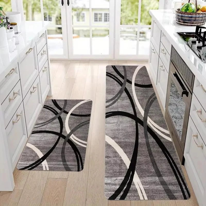 A gray and white geometric non-slip rug with black curved lines placed on a light wood floor.