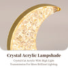 A close-up of a crystal acrylic lampshade with a gold rim and faceted light diffusing through.