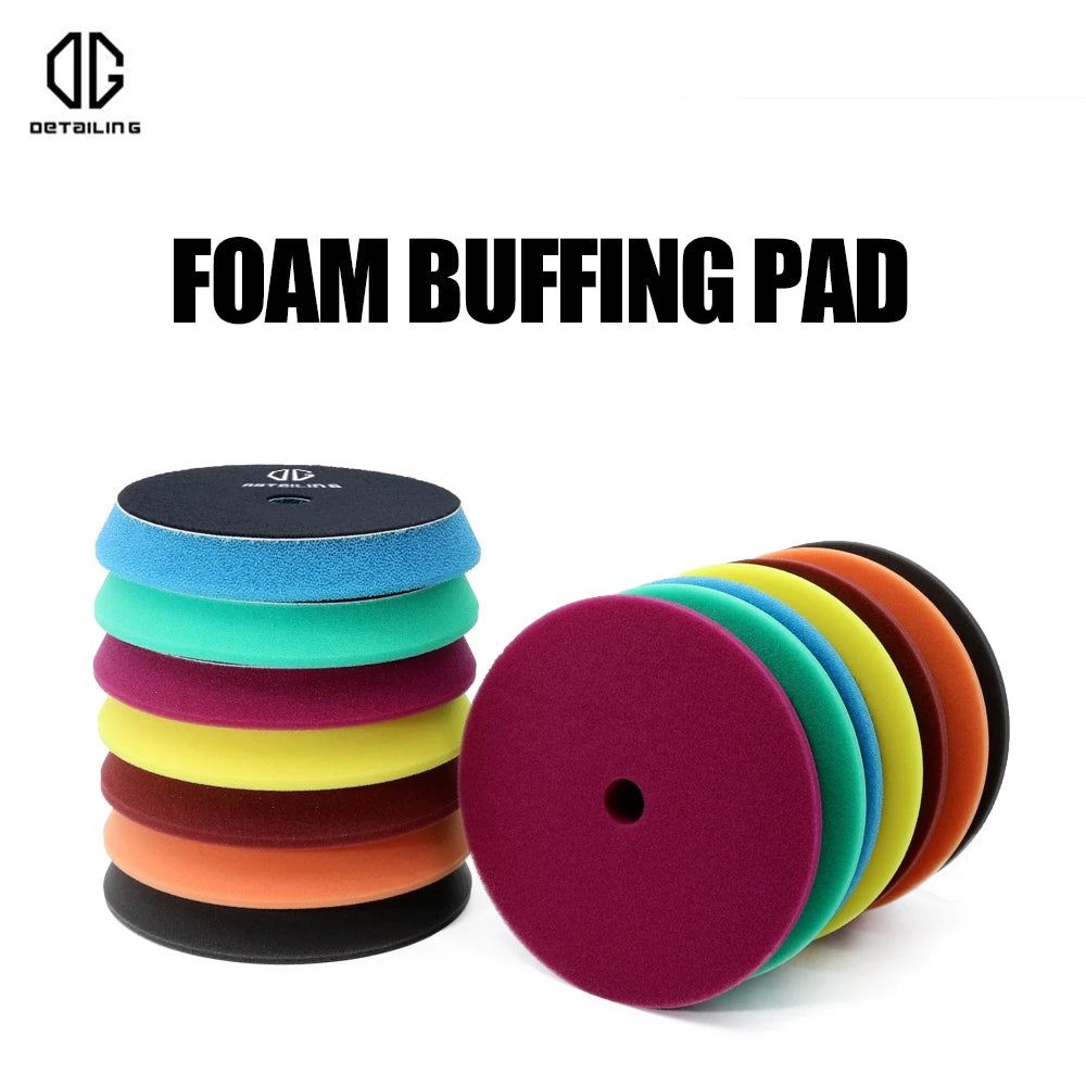 A stack of various colored foam buffing pads for car detailing, including blue, green, yellow, orange, and black.