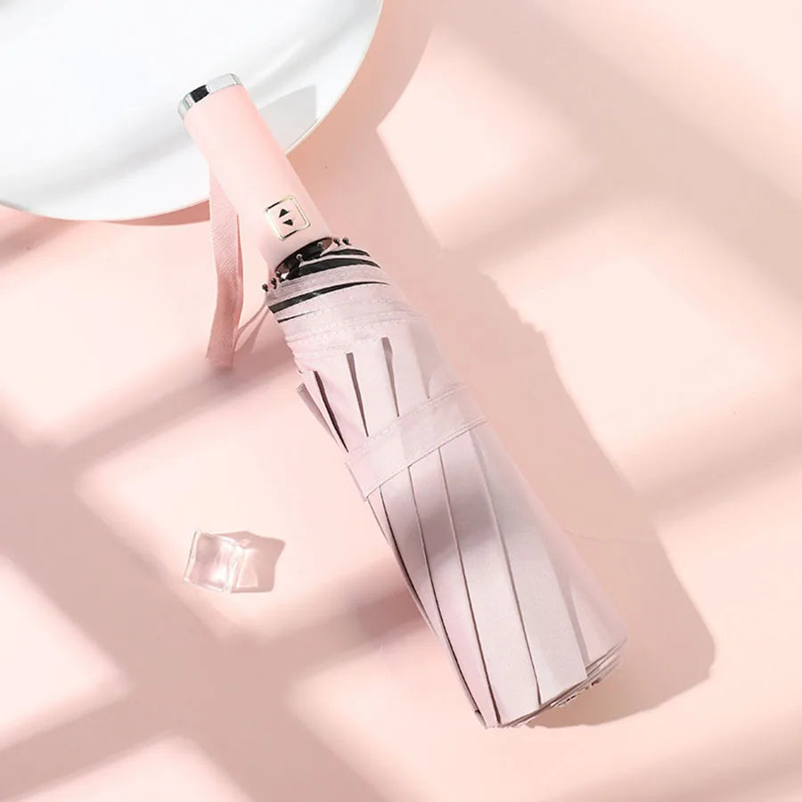 A pink automatic foldable umbrella with a silver handle and protective sleeve is shown against a light background.