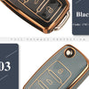 A close-up view of a black TPU silicone car key case with gold accents, showing the key slot and a protective packaging label