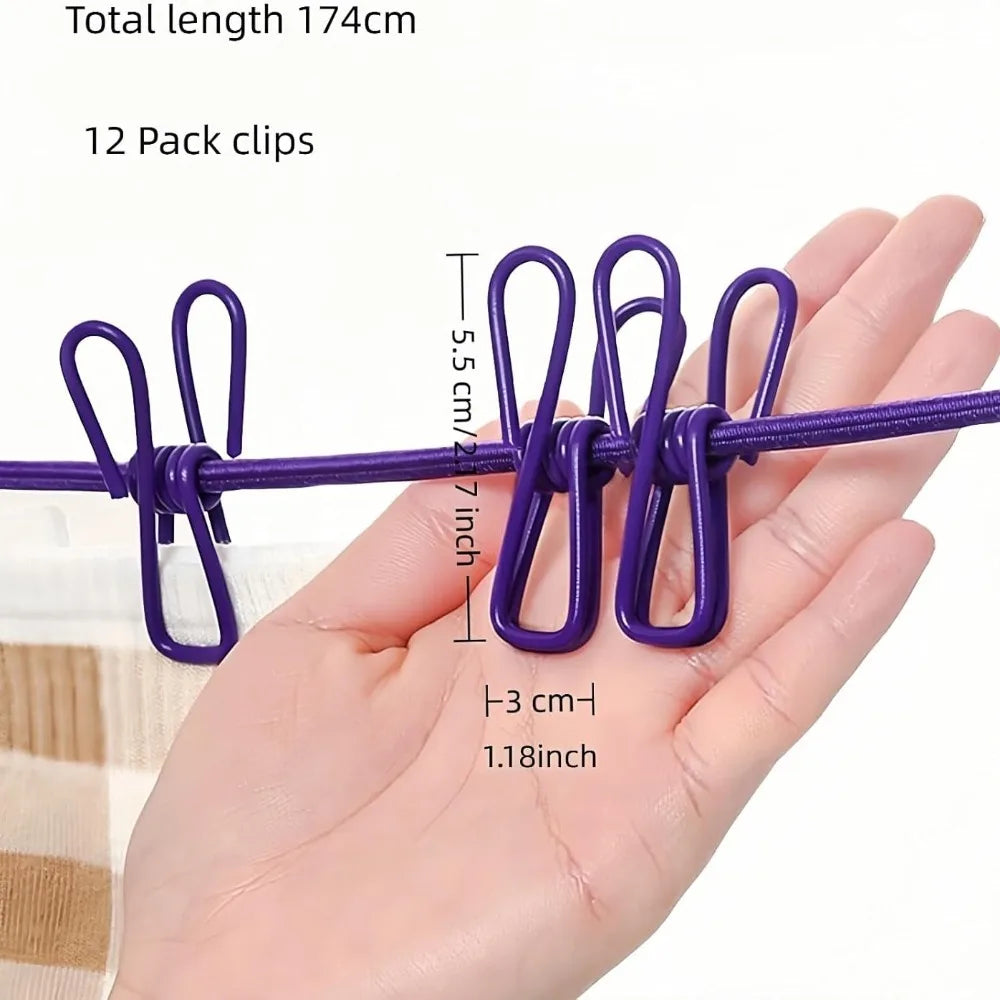 A hand holds a purple elastic travel clothesline with twelve non-slip clips.