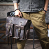 Eine Person hält eine dunkelbraune Vintage-Ledertasche für Laptops.