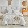 A white microfiber duvet cover set with an embossed leaf pattern displayed on a bed.