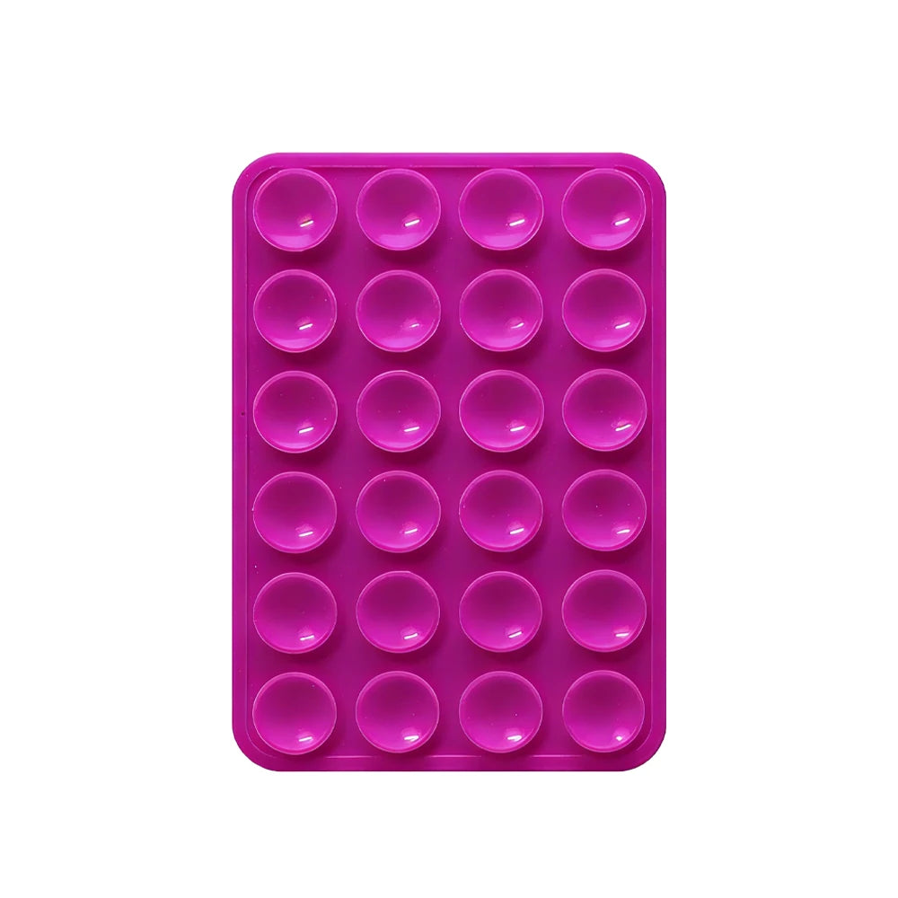 A pink silicone suction pad with multiple circular indentations for phone mounts.