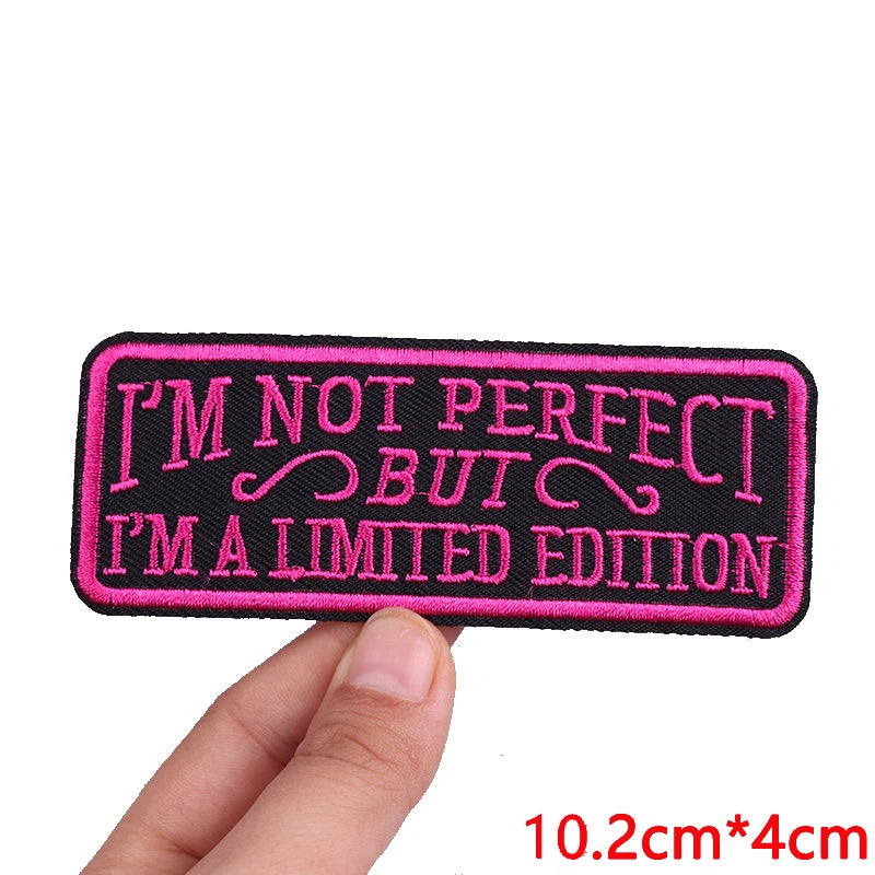 Black embroidered iron-on letter patch with pink text that reads I'M NOT PERFECT BUT I'M A LIMITED EDITION