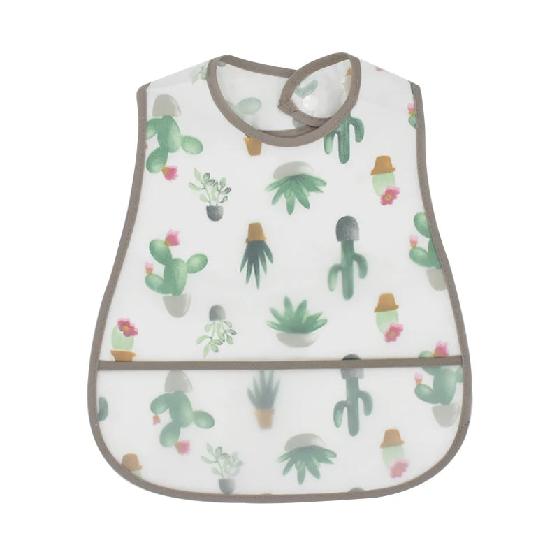 A white baby feeding bib with a brown trim featuring a pattern of green cacti and small pink flowers.