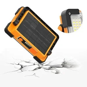 An orange portable solar and USB LED work floodlight with a black panel and an attached light source.