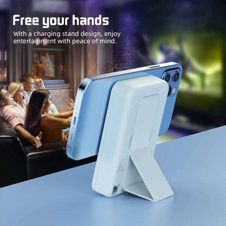 Hellblaue portable magnetische kabellose Powerbank auf einem Tisch, mit Menschen im Hintergrund, die Spaß haben