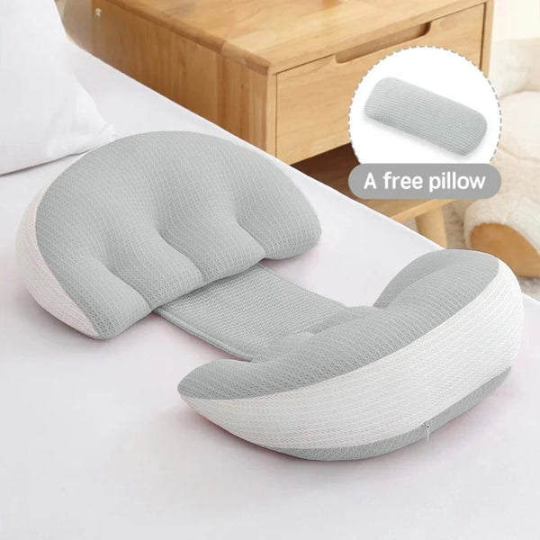 Almohada ergonómica gris para dormir durante el embarazo con ribete blanco sobre una superficie blanca.