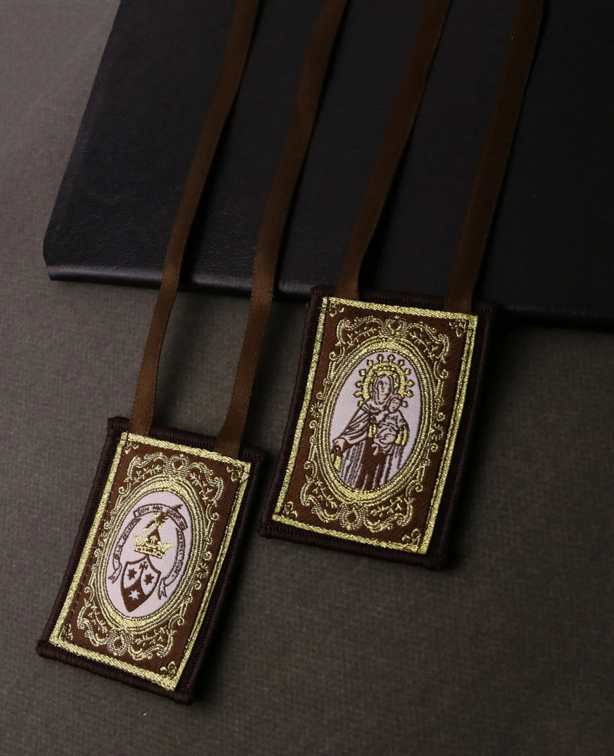 A brown scapular necklace with an ornate pendant featuring a depiction of the Immaculate Heart.