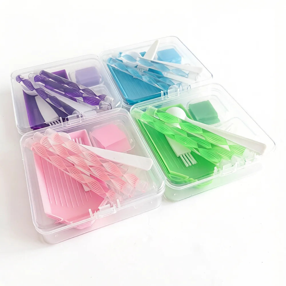 A clear plastic storage box containing various diamond painting tools and accessories in multiple colors.