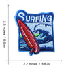 Blue embroidered patch with the word SURFING and a red fish swimming in blue water.