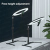 A black foldable overhead tripod with a ring light is shown on a white table.