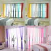 A collection of sheer voile curtains in various pastel colors like yellow, blue, green, and pink filtering light.