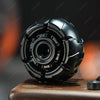 A close-up shot of a black fidget spinner resting on a wooden surface.
