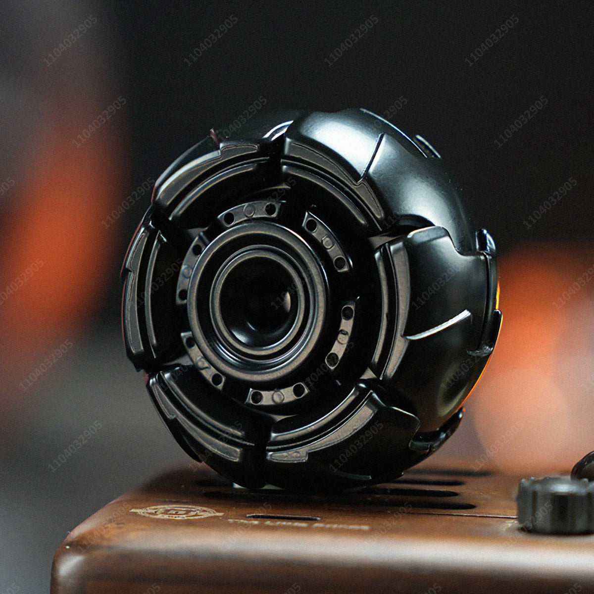A close-up shot of a black fidget spinner resting on a wooden surface.