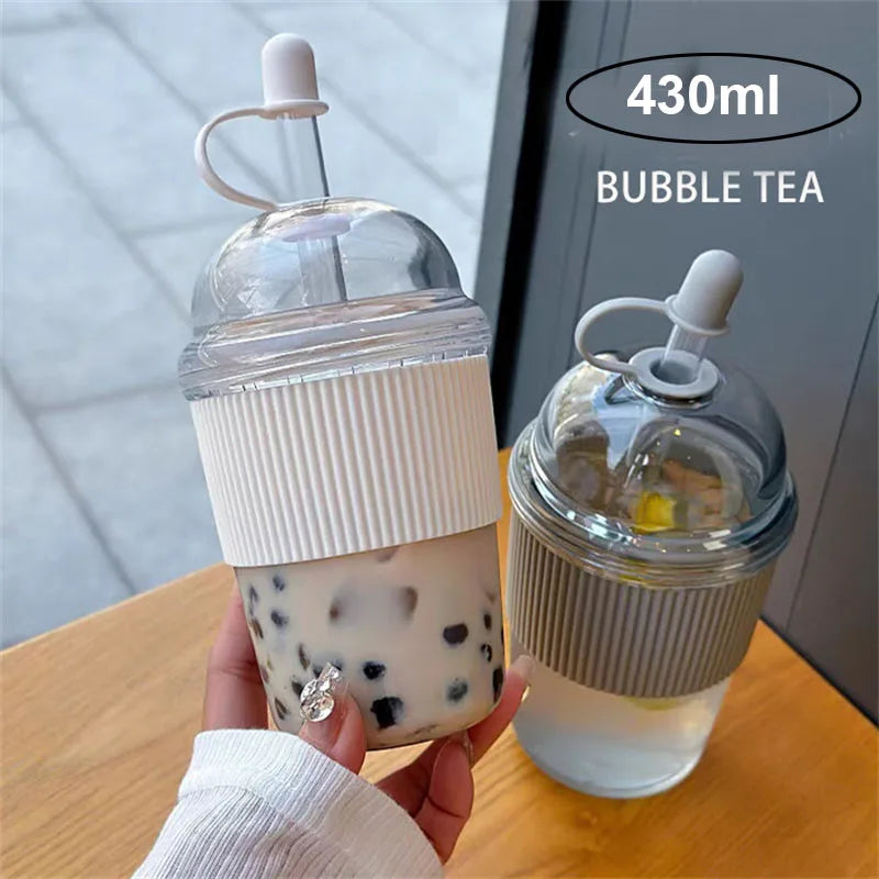 Klares Glas mit Bubble Tea neben einem Plastikstrohhalmglas (430ml Bubble Tea).