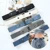 A collection of various colored elastic belts for men and women shown alongside a denim garment.