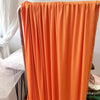 Orange stretch jersey fabric draped vertically for decor or backdrop.