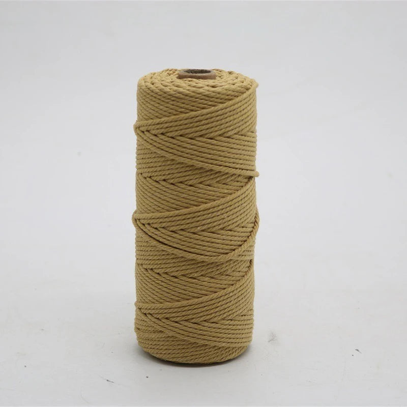 A spool of natural beige cotton macrame cord used for crafting.