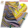 A close-up view of a vibrant pink, yellow, and purple African wax print fabric with swirling patterns.