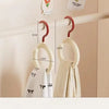 A white wall-mounted organizer hook displaying a folded cream colored scarf and hat.