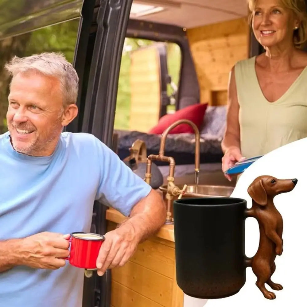 A man holds a red coffee mug in the context of a Dachshund coffee mug with a 3D puppy handle.